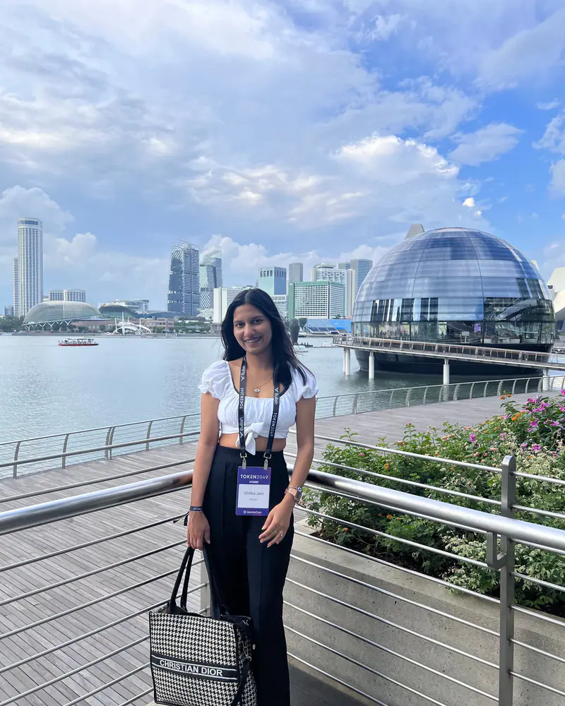 Shilika Jain wearing a conference badge on the Marina Bay promenade in Singapore