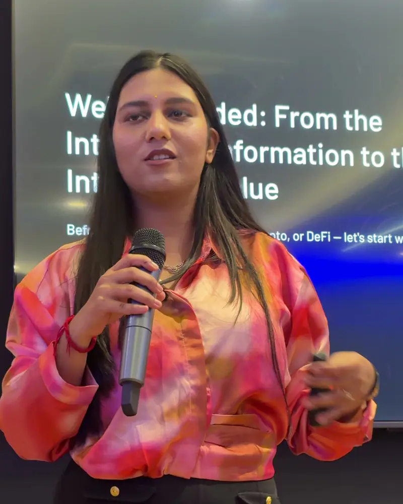 Shilika Jain smiling mid-talk on stage, microphone in hand